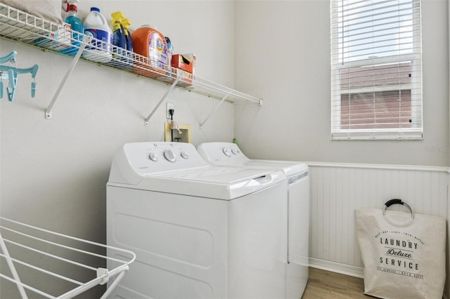 29704 Eagle Station Dr, Wesley Chapel, FL 33543 - laundry room featuring washing machine and dryer, a wainscoted wall, plenty of natural light, and wood finished floors