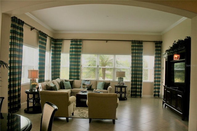 living room featuring crown molding, arched walkways, and plenty of natural light
