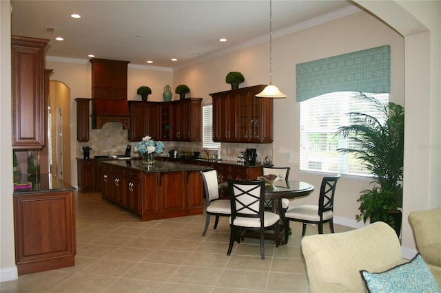 kitchen featuring arched walkways, decorative backsplash, light tile patterned floors, and glass insert cabinets