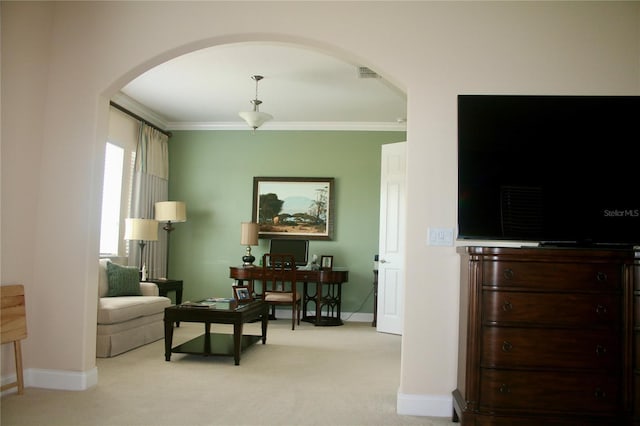 sitting room with crown molding, visible vents, baseboards, light colored carpet, and arched walkways