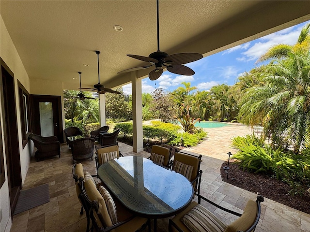 view of patio / terrace featuring outdoor dining area, ceiling fan, and an outdoor pool