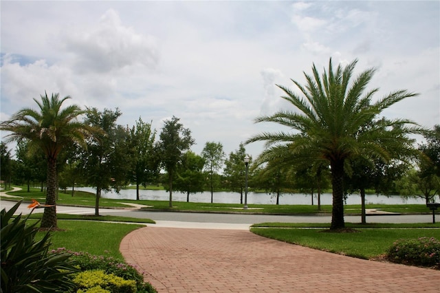 surrounding community with a water view and a yard