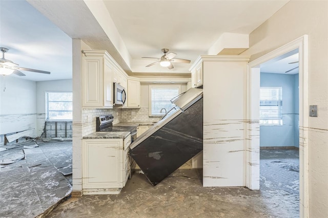 15406 2nd St E, Madeira Beach, FL 33708 - kitchen featuring a ceiling fan, a healthy amount of sunlight, and stainless steel appliances