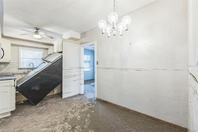 15406 2nd St E, Madeira Beach, FL 33708 - kitchen featuring a healthy amount of sunlight, baseboards, ceiling fan with notable chandelier, and a sink