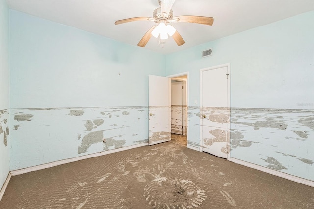 15406 2nd St E, Madeira Beach, FL 33708 - empty room with visible vents, carpet, ceiling fan, and a wainscoted wall