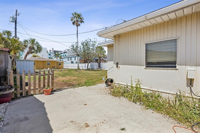 15406 2nd St E, Madeira Beach, FL 33708 - view of side of property with a patio, fence, and a yard