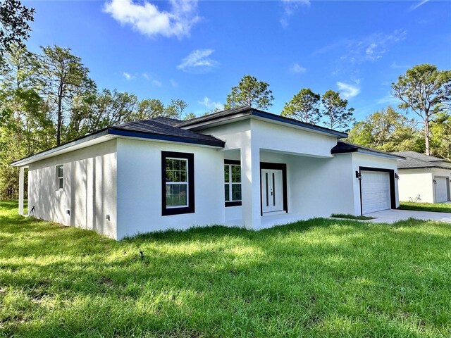 view of home's exterior featuring a lawn, a garage, stucco siding, and driveway