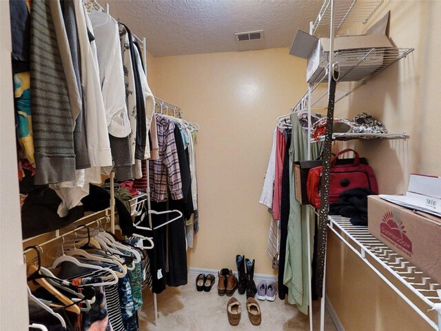 walk in closet featuring visible vents and carpet floors