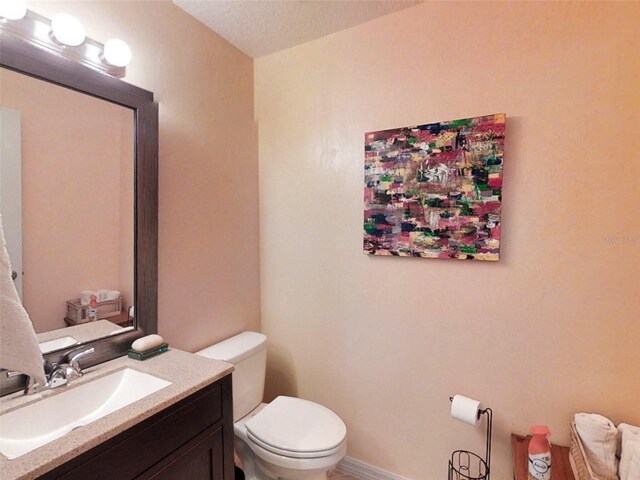 half bathroom with toilet and vanity