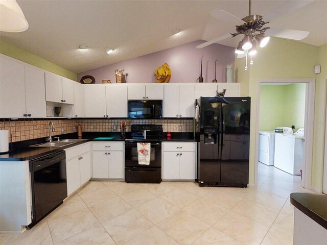 kitchen with backsplash, vaulted ceiling, washing machine and dryer, a sink, and black appliances