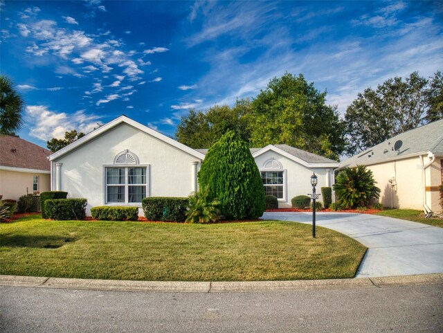 single story home featuring stucco siding, driveway, and a front lawn