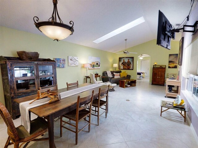 dining space featuring ceiling fan and lofted ceiling with skylight