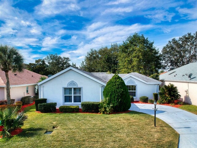 ranch-style home with stucco siding and a front yard