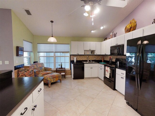 kitchen featuring a ceiling fan, dark countertops, a sink, and black appliances