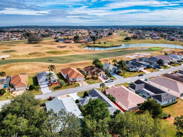 drone / aerial view with a water view, golf course view, and a residential view