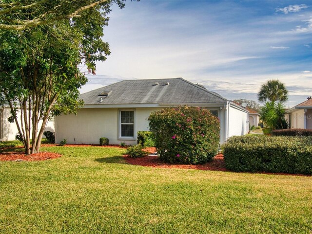 view of front of house featuring stucco siding and a front lawn