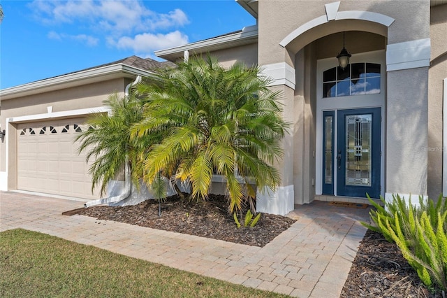 23533 Valderama Ln, Sorrento, FL 32776 - doorway to property featuring decorative driveway, an attached garage, and stucco siding