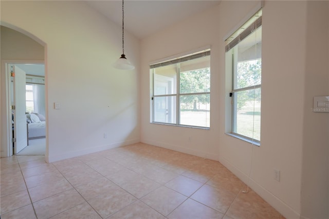 23533 Valderama Ln, Sorrento, FL 32776 - unfurnished dining area with arched walkways, baseboards, and light tile patterned floors