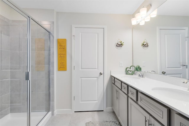 full bath with a sink, baseboards, and a stall shower