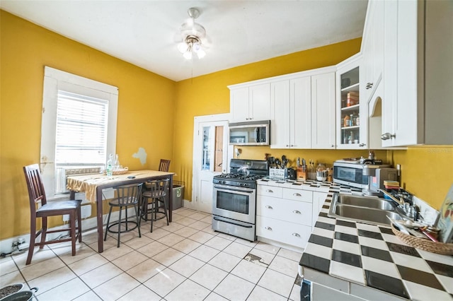 419 Palm Ave, Eustis, FL 32726 - kitchen with a sink, appliances with stainless steel finishes, white cabinets, and glass insert cabinets