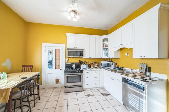 419 Palm Ave, Eustis, FL 32726 - kitchen with a sink, light tile patterned flooring, glass insert cabinets, stainless steel appliances, and white cabinetry