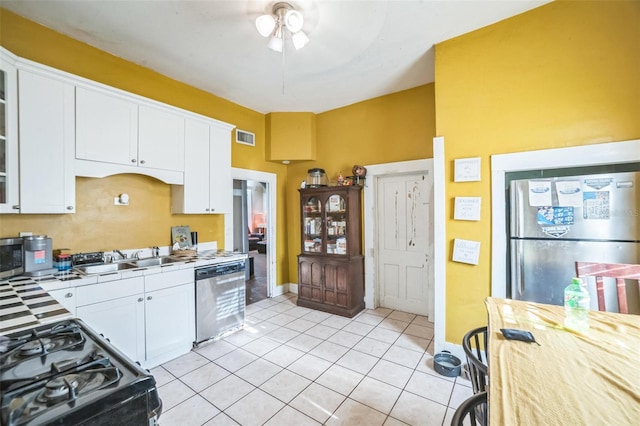 419 Palm Ave, Eustis, FL 32726 - kitchen featuring white cabinets, appliances with stainless steel finishes, a sink, tile counters, and visible vents