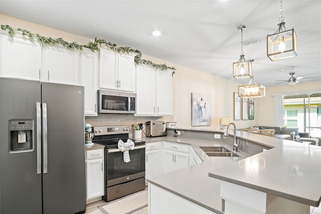 kitchen featuring backsplash, visible vents, appliances with stainless steel finishes, a sink, and a peninsula