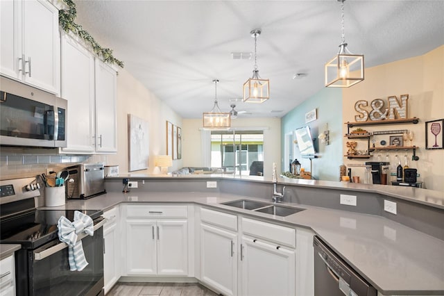 kitchen with visible vents, white cabinets, tasteful backsplash, a sink, and appliances with stainless steel finishes