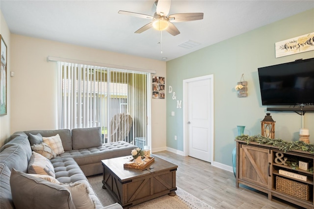 living area featuring a ceiling fan, baseboards, visible vents, and light wood finished floors
