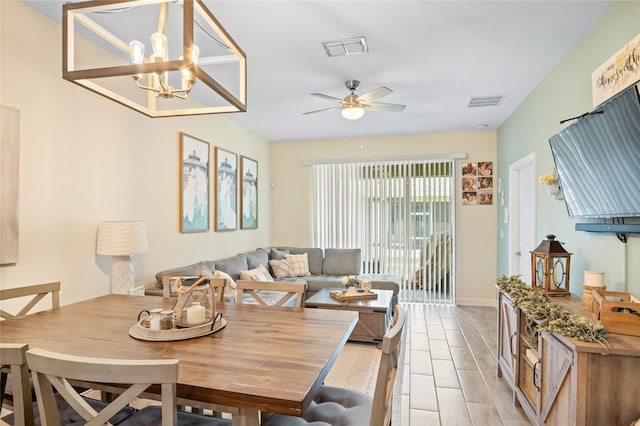 dining room featuring baseboards, ceiling fan with notable chandelier, and visible vents