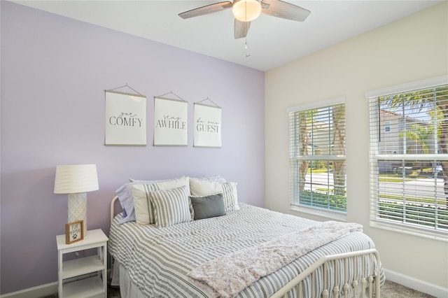 carpeted bedroom with baseboards and a ceiling fan