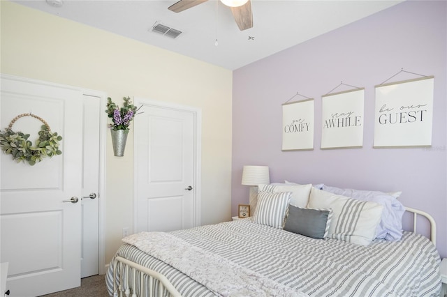 bedroom with visible vents, ceiling fan, and dark colored carpet