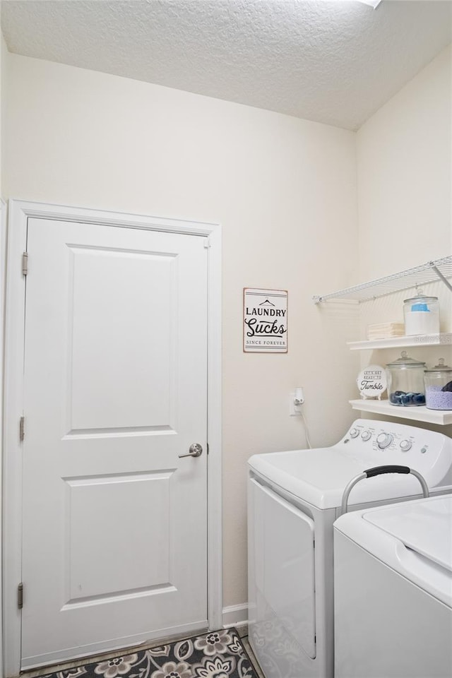 washroom with independent washer and dryer, a textured ceiling, and laundry area