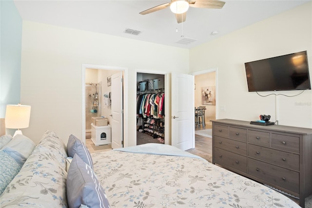 bedroom with connected bathroom, visible vents, a walk in closet, and a closet