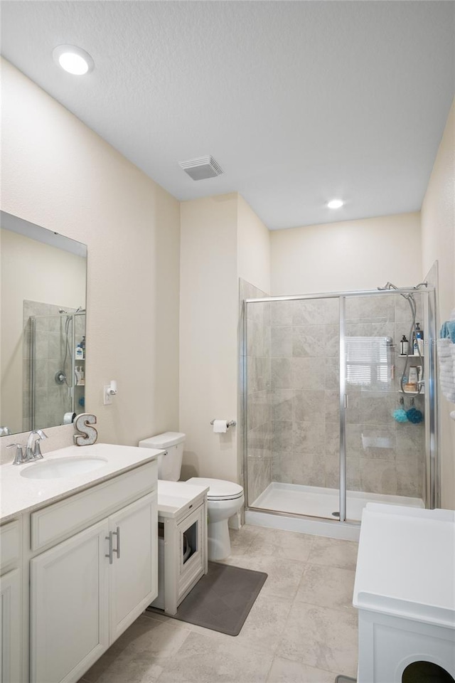 full bath with visible vents, a stall shower, toilet, and vanity