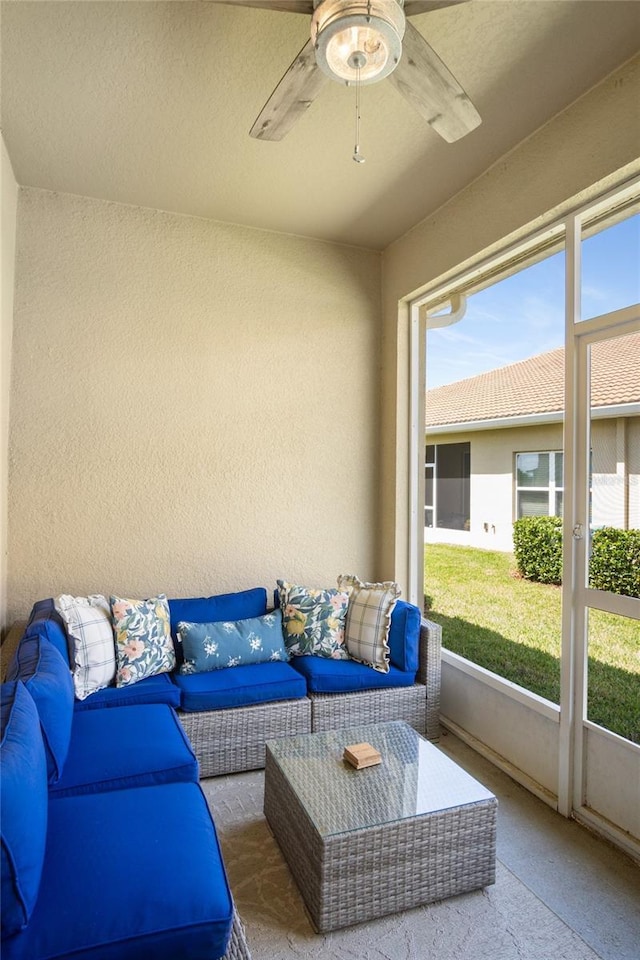 sunroom / solarium featuring a healthy amount of sunlight, ceiling fan, and an outdoor living space