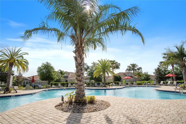 pool with a patio and fence