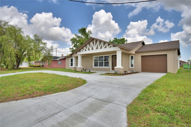 view of front of house featuring driveway, a garage, a front lawn, and stucco siding