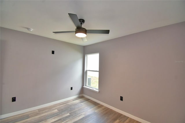 unfurnished room featuring baseboards, light wood-style floors, ceiling fan, and a smoke detector