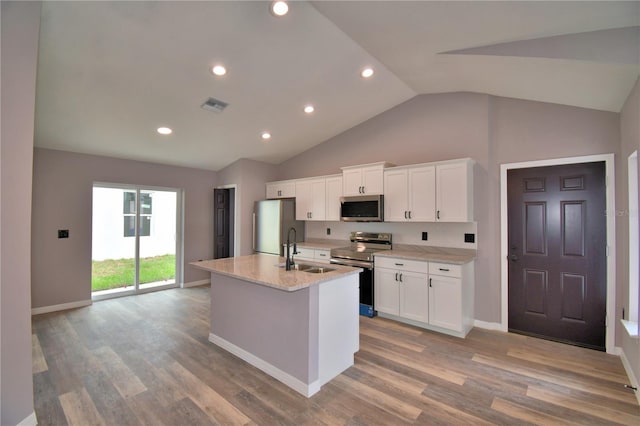 kitchen featuring stainless steel appliances, a sink, an island with sink, white cabinetry, and recessed lighting