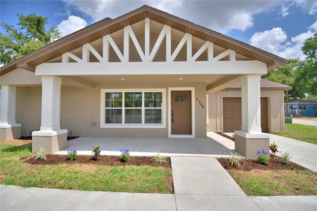 view of front of property featuring covered porch and stucco siding