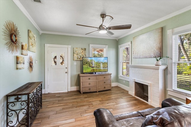 living room featuring light wood-style floors, a ceiling fan, healthy amount of natural light, and ornamental molding