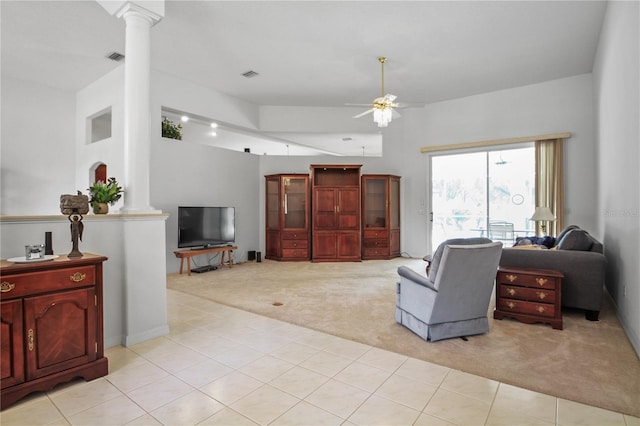 living room featuring visible vents, decorative columns, high vaulted ceiling, light colored carpet, and a ceiling fan