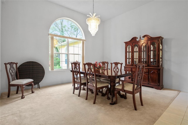 carpeted dining space with tile patterned floors and a chandelier