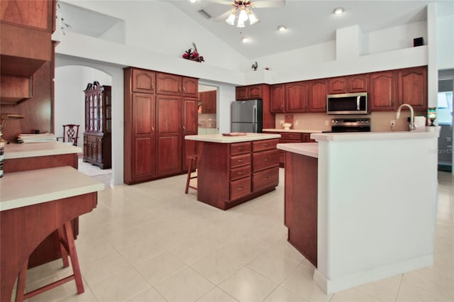 kitchen with ceiling fan, visible vents, arched walkways, lofted ceiling, and stainless steel appliances