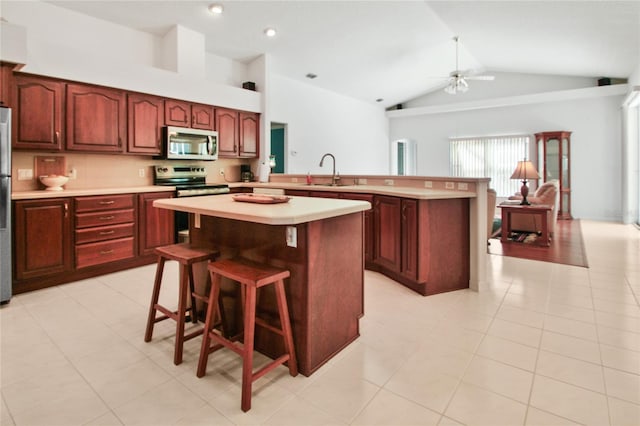 kitchen featuring a ceiling fan, a sink, light countertops, a peninsula, and stainless steel appliances