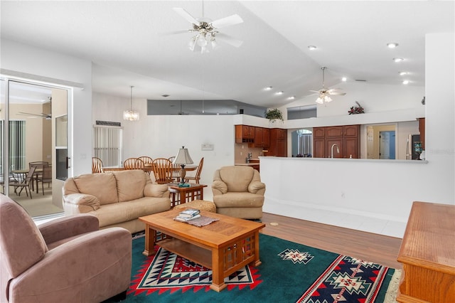 living area featuring ceiling fan, wood finished floors, and lofted ceiling