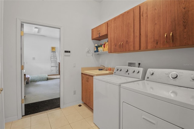 laundry area featuring cabinet space, separate washer and dryer, baseboards, and a sink