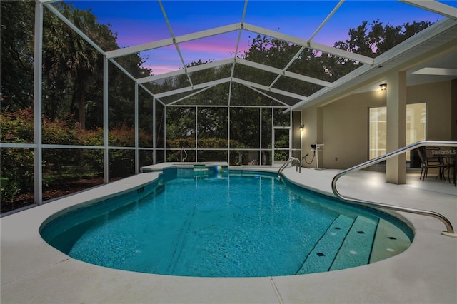 pool at dusk with a lanai, a patio area, and an outdoor pool
