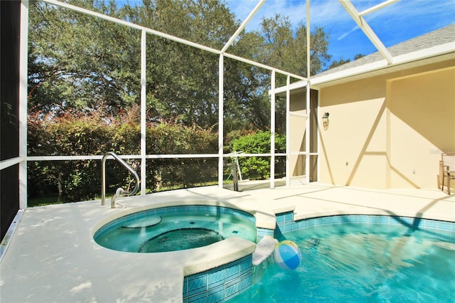 view of pool featuring glass enclosure, a patio area, and a pool with connected hot tub